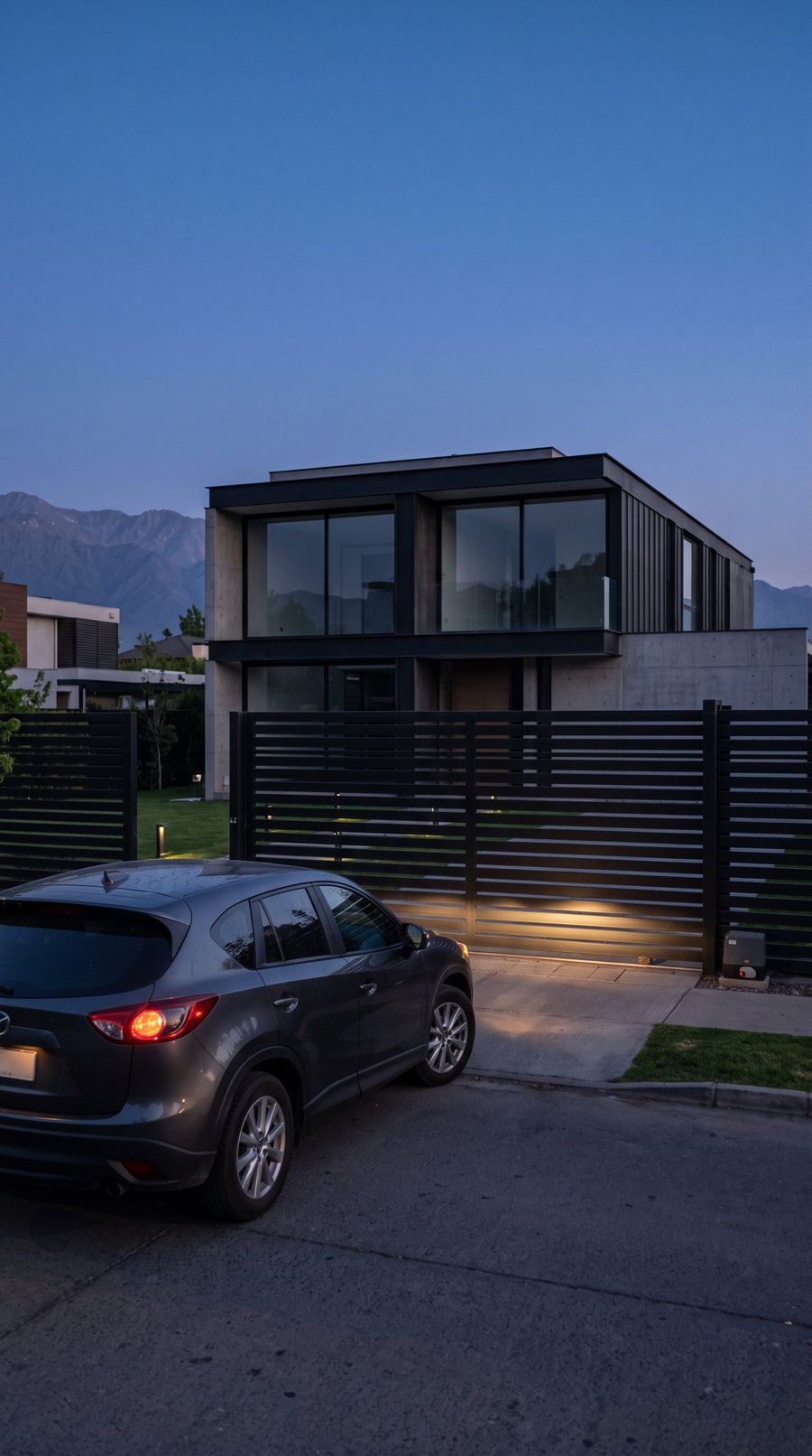 Casa moderna de noche, con el portón cerrado y las luces apagadas